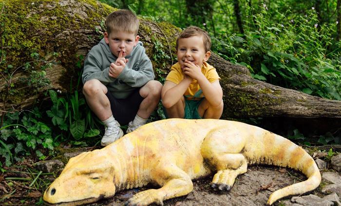 Two young boys saying 'SShhhh' whilst Sleep the Dinosaur sleeps.
